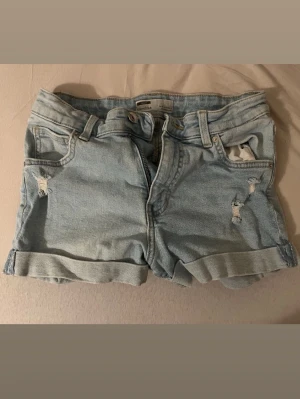 Korta ljusblå jeans shorts Bershka - Korta ljusblå jeansshorts från Bershka i storlek 36.. Snygga och bekväma för vardagsbruk!Köpta för 300kr. Använda 2 gånger så i superbra skick.