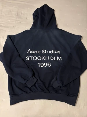 Mörkblå hoodie Acne Studios - Mörkblå hoodie från Acne Studios. Storlek S men är ganska stor i storleken, skulle säga att den passar M/L för lite mindre baggy look. 