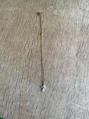 Guldkedja med korshänge - Fin tunn guldfärgad kedja med ett korshänge. Hänget är dekorerat med små vita stenar som ger ett elegant och klassiskt utseende. Perfekt som vardagssmycke eller present. Rostfritt stål har inte använts på några månader och den har en knut på sig 