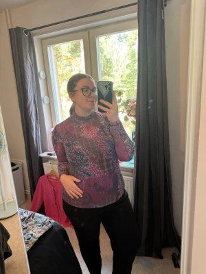 Mönstrad mesh polotopp i lila och rosa - Säljer en tunn och stretchig mesh polotopp med lång ärm. Toppen har ett unikt mönster i lila, rosa och blå toner, med inslag av rutigt och blommigt. Perfekt att styla lager på lager eller bära som den är för en cool vibe. Från märket Odd Molly i storlek 4 som enligt deras storlekguide motsvarar en storlek XL. Jag har vanligtvis en 4/XL. Men denna är något liten på mig. Mycket fint skick, jag hittar inga synliga anmärkningar eller defekter. 