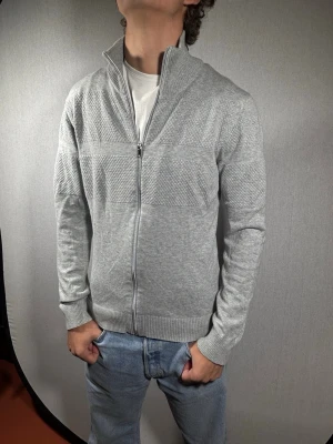 Jack & Jones kofta S - Hej och välkommen till byTorén. Detta är en kofta från Jack & Jones i storlek S med normal passform. Modell på bild är ca 182, 67kg. Plagget är i bra skick utan några defekter. Tveka inte på att höra av dig, även om det skulle vara minsta lilla;)