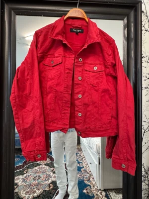 MARC LAUGE röd jacka - This is a red denim jacket from the brand Marc Lauge, labeled as size XXL. The jacket features a classic button-up front, two chest pockets with button flaps, and buttoned cuffs. The label inside reads 'MARC LAUGE ITALY CLASSIC'.
