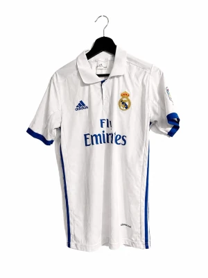 Real Madrid Cristiano Ronaldo #7 Adidas vintage Fotbollströja ⚽️🤍 - 🤍 Klassisk Real Madrid-tröja från Adidas med Cristiano Ronaldo #7 på ryggen.  ⚽️ Vit med blå detaljer, Real Madrid-klubbmärke, Adidas-logga och Fly Emirates sponsor framtill. Ronaldo 7-tryck baktill – riktigt snygg äldre Real Madrid-design.  ✨ Fint skick 👕 Klassisk fotbollströja / jersey 🐐 Cristiano Ronaldo #7 ⚪ Real Madrid 🔵 Adidas Climacool 📦 Skickas snabbt 💬 Skriv gärna vid frågor eller om du vill ha mått  🛍️ Kolla gärna min profil för andra plagg