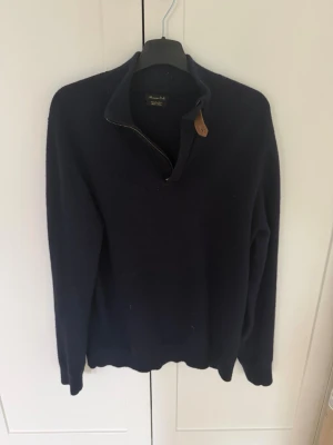 Massimo dutti stickad tröja - En stilren mörkblå tröja med halv dragkedja och hög krage. Tröjan har långa ärmar och ribbade muddar vid ärmslut och nederkant. Perfekt för lager-på-lager och enkel att matcha med olika outfits. I grymt skick och är i storlek Medium