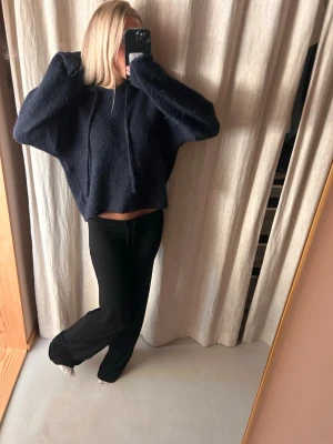 Mörkblå hoodie från Gina Tricot - Mysig mörkblå hoodie från Gina Tricot i fluffigt material. Modellen är croppad med huva och har en avslappnad passform. Perfekt för dig som gillar en chill och trendig stil. Den är lite nopprig 