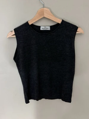 Svart ärmlös topp från Valentino - Stilren svart ärmlös topp från Valentino med rund halsringning. Toppen har en enkel och klassisk design som passar till många olika outfits. Materialet känns mjukt och bekvämt mot huden. 0767