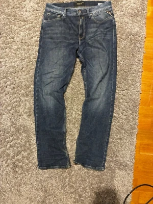 Mörkblå raka jeans - Säljer ett par mörkblå jeans med raka ben och klassisk femficksdesign. Jeansen har kontrastsömmar och en patch bak i midjan. Perfekta till vardagslooken och passar till det mesta. Materialet är denim i bomull. Den är 93 cm lång och 35 cm i midjan