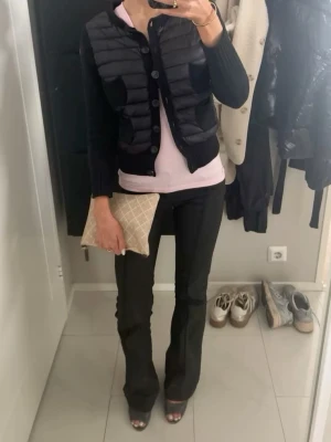 Svart cardigan från Moncler - Snygg och trendig cardigan jacka från Moncler med stickade ärmar i ull och quiltad framsida som stängas med knappar. Det står storlek M men tyget har troligen dragit ihop sig efter tvätt så passar mer som xs/xxs då ärmarna är lite korta men går perfekt att vika upp för en trekvartsärmad look.🌸 Så snygg och fräsch nu till hösten och skolstart! Självklart äkta!  Skriv för frågor eller mått och köp gärna så postar jag omgående🙌💫📦
