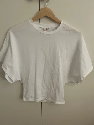 Vit t-shirt  - Säljer en enkel och stilren vit  t-shirt med snygg passform och korta ärmar. Den är från Nelly i storlek xxs. Liten fläck vid halsen som säkert går bort i tvätten. Om de skulle vara uppskattat kan jag tvätta den innan ni köper 
