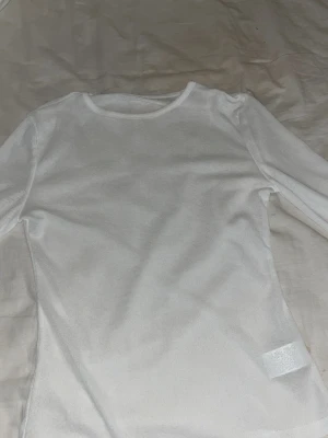 Vit genomskinlig långärmad topp 💞 - En enkel och stilren vit långärmad topp med rund halsring. Lite genomskinlig är den men ändå söt.Jag säljer den på grund av att den är lite för genomskinlig för min smak och lite stor.💞