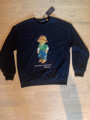 Mörkblå sweatshirt med Ralph lauren - Tja! Säljer en jättesnygg mörkblå sweatshirt från Ralph lauren.                                                                              Storleken är M och måtten finns på sista bilderna 📐.    Den är aldrig använd, så skicket är helt nytt.                    Priset kan diskuteras och skickar inom 24 Tim 💨☺️