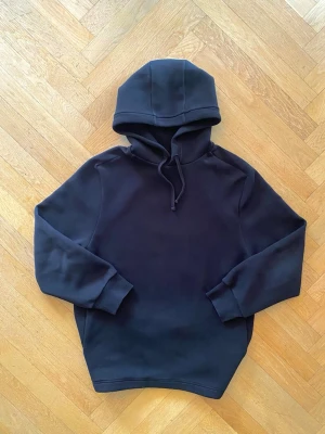 Svart hoodie med huva och dragsko - Svart Hoodie från COS.  Stilren med gömda fickor, stor luva och tjockt tyg. Sitter lagom på storlek M och oversize/loose för storlek S.  Nypris 1 300 kr