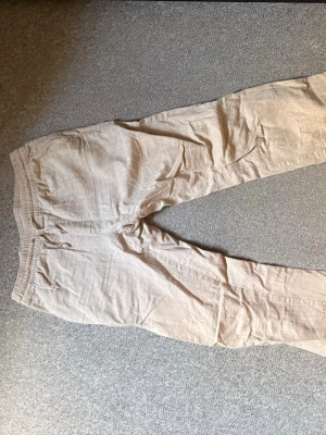 Beige linnebyxor med resårmidja - Säljer ett par ljusbeige linnebyxor i storlek S. Byxorna har avslappnad passform, resår i midjan och är gjorda i en skön linne- och bomullsblandning. Perfekta för en chill och stilren look. Från Cubus 