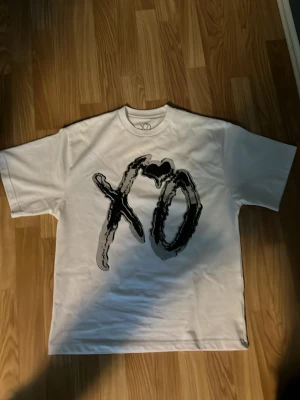 Vit t-shirt med XO-tryck - Säljer en vit weeknd merch som jag aldrig har använt samt den är M men passar som S. Den är jättebra skick