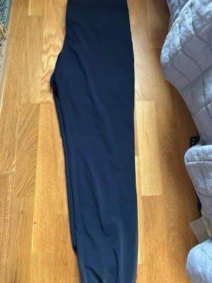 Mörkblå golfbyxor från Jlindberg raka ben - Säljer ett par mörkblå kostymbyxor med raka ben och hög midja. Byxorna har en klassisk, stilren look och är tillverkade i ett slätt tyg som ger en dressad känsla. Perfekta för dig som vill ha en clean och enkel stil.