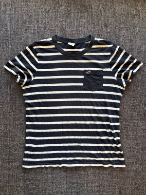 Hollister T-shirt ~ vintage  - 🎉 20% rabatt om du följer min profil och handlar direkt! 😊  Sjukt sällsynt Hollister T-shirt i storlek M – blå/vit randig vintage 2000’s modell med klassisk design och hög kvalitet. En eftertraktad modell som inte längre produceras och passar perfekt året om. 📦 Skickas inom 24h, kan gå ner lite i pris vid snabb affär! ✌️