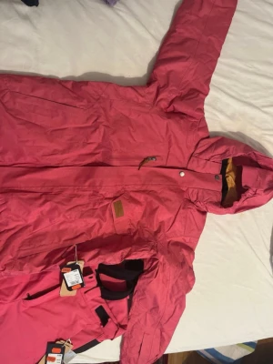 Rosa skidkläder - Dom är sprillans nya.  Passar S/M                                             Snygg rosa skidjacka med huva och dragkedja framtill. Jackan har en bröstficka med dragkedja och justerbar huva. Materialet ser ut att vara slitstarkt och vattenavvisande, perfekt för blåsiga dagar. Fodret är i kontrastfärg vid huvan för extra stil. Och skidbyxor perfekt för en smidig tur och snyggt. 