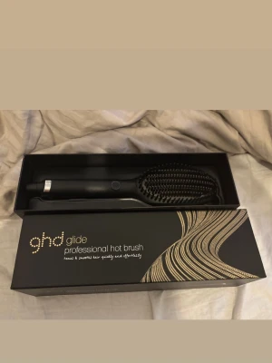 ghd Glide värmeborste - ghd Glide professional hot brush är en svart värmeborste med keramiska borst och elegant design. Perfekt för att snabbt och enkelt styla och släta ut håret. Kommer i originalförpackning med snygg gulddetaljerad box. Endast använd en gång!!!! Ny pris 1500kr mitt pris 1000kr