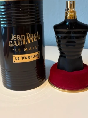 Jean Paul Gaultier Le Male Le Parfum - Säljer en Jean Paul Gaultier Le Male Le Parfum. Flaskan har en unik design i form av en svart manlig torso med matta och blanka ränder samt guldfärgad spraytopp. Kommer i en svart metallburk med gulddetaljer och står på en röd sammetsbas. Ops har tappat bort lådan Tyvär men parfymen är helt orörd 