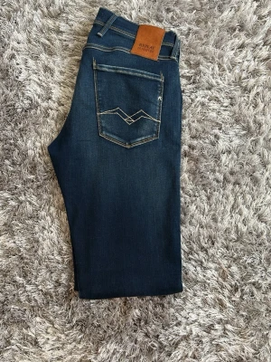Replay Anbass Hyperflex Jeans – W30/L32 - Exklusiva Replay Anbass Hyperflex jeans i en stilren mörkblå premiumtvätt. Tillverkade med Replay’s populära Hyperflex-material som ger en perfekt kombination av komfort, stretch och passform samtidigt som jeansen håller sin form.  Jeansen är i mycket fint skick och ser nästan nya ut. Väldigt väl omhändertagna med snygg denimkänsla och den klassiska Anbass slim fit-passformen.  ✔️ Original Replay ✔️ Modell: Anbass Hyperflex ✔️ Storlek: W30 L32 ✔️ Slim fit ✔️ Premium stretch-denim ✔️ Mörkblå tvätt 