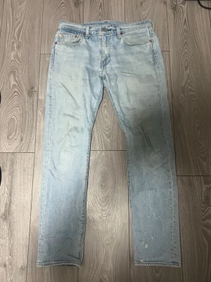 Ljusblå jeans från Levi's - Säljer ett par klassiska ljusblå jeans från Levi's med rak passform och fem fickor. Jeansen har en vintagekänsla och är tillverkade i slitstark denim. Perfekta för en avslappnad och trendig look. Pris kan diskuteras 