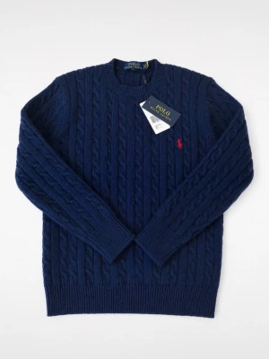 Mörkblå kabelstickad tröja Polo - Kabelstickad tröja i mörkblått från Polo Ralph Lauren. Klassisk rund halsringning, långa ärmar och ribbade muddar. Liten röd logga broderad på bröstet. Perfekt för lager på lager och riktigt snygg till jeans.