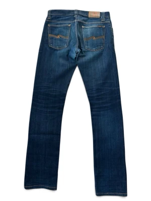 Nudie Jeans GRIM TIM dry stretch selvedge jeans - Säljer ett fetta par Nudie Jeans GRIM TIM dry stretch selvedge jeans. Har snygga påbörjade fades och är riktiga sköna samt bekväma, storlek W29 L32.  Mått: Midja - 38 cm Längd - 102 cm Benöppning - 17,5 cm  Skriv vid vidare funderingar!