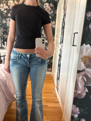 Low waist bootcut jeans ljusblå  - Säljer ett par superfina  ljusblå bootcut jeans med låg midja med ”slitningar” fram och bak. Dem är ifrån Young Gina och är i storlek M men skulle säga att dem passar S också 🌸