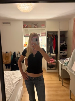 Svart croppad topp med ringdetalj - Snygg svart croppad topp med v-ringning och en cool ringdetalj framtill. 