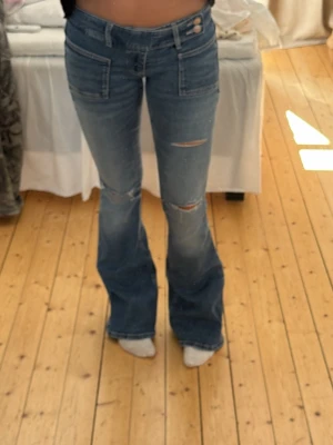 Blå bootcut jeans med slitningar - Superfina jeans från Gina, lågmidjade 