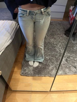 Ljusblå bootcut jeans med brodyr - Säljer ett par ljusblå bootcut jeans . 