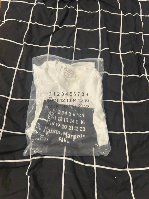 🔥 Maison Margiela Paris T-Shirt Vit – Storlek M – Endast testad 🔥 - ✅ Maison Margiela Paris T-shirt ✅ Storlek M ✅ Endast testad – i nyskick ✅ Allt medföljer (påse & tags) ✅ 100% äkta ✅ Pris kan diskuteras vid snabb affär ✅ Fraktas samma dag eller senast dagen efter betalning  Perfekt för dig som gillar exklusiv designerstil. Hör av dig om du har frågor eller vill ha fler bilder!