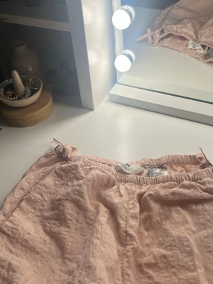 Ljusrosa linnebyxor från H&M - Ljusrosa linnebyxor från H&M med resår i midjan och avslappnad passform. Byxorna är tillverkade i ett mjukt och lätt material som känns skönt mot huden. Perfekta för en chill dag hemma eller när du vill ha något bekvämt på dig. Org pris 399 så du sparar 150 kr💓💓😽