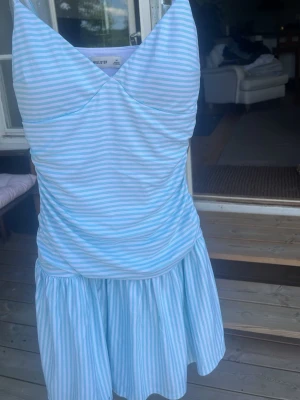 Blåvit randig klänning Hollister - Blå randig klännning från hollister med inbyggda shorts, padding där uppe och extremt bekvämt material, aldrig andvänd. Pris kan diskuteras 