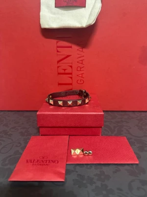 Valentino Garavani armband - Snyggt armband från Valentino Garavani. Väldigt snygg och får mycket blickar och komplemanger för färgen. Exktra bitar ingår. Den stora boxen där bak ingår inte.