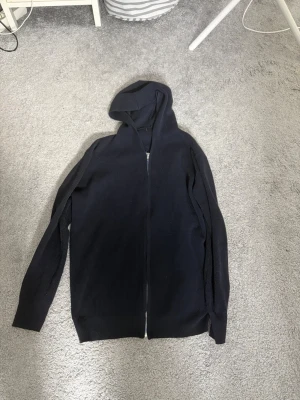 Ribbad zip hoddie  - Mörkblå ribbad Zip-Up 💙  Stilren och klassisk mörkblå ribbad Zip-Up med huva. Perfekt som ett extra lager och passar lika bra till vardags som till en mer uppklädd stil.  📏 Storlek: S 🎨 Färg: Mörkblå ✨ Skick: Bra skick 🧥 Modell: Ribbad Zip-Up med huva 💰 Pris: 399 kr  Säljes då den inte längre kommer till användning.