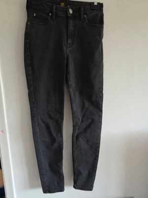 Svarta jeans från Lee - Snygga svarta jeans från Lee med klassisk femficksmodell och raka ben. Jeansen har normal midja och är tillverkade i ett mjukt denimtyg som ger en skön passform. Perfekta för dig som gillar en stilren och enkel look.