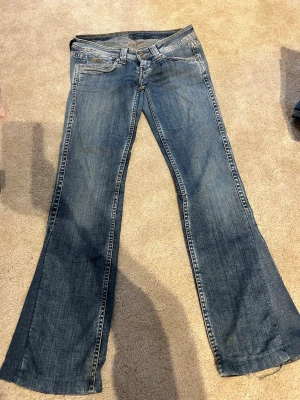 Blå bootcut jeans med låg midja - Säljer ett par klassiska blå  bootcut jeans med låg midja och fem fickor. Jeansen är i lite slitna nere vid byxbenen men annars i bra skick. De kommer ifrån pepe jeans och har midjan 30 och längd 34 