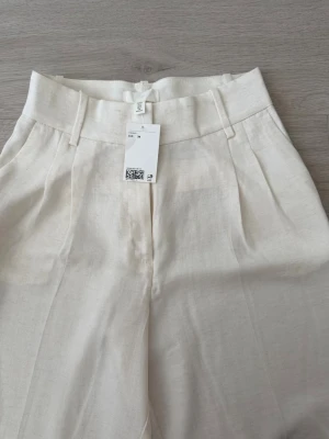 Vida linnebyxor i offwhite - Raka ”oversized tygbyxor”. Otroligt fina men för stora. Jag brukar har storlek 36/S i byxor men dessa i 34 är för stora plus väldigt långa. Köpta för 349kr. Helt oanvända! 