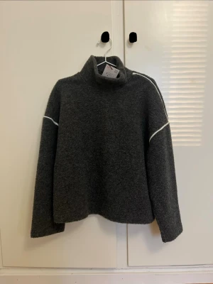 Stickad tröja med kantband - Grå Stickad tröja med vita kantband i kontrast. Polokrage. Från Zara i strl S. Helt ny med prislapp, aldrig använd. Perfekt nu till hösten. 