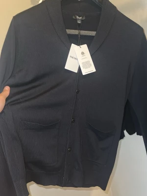 Mörkblå cardigan från Reiss - Mörkblå cardigan/blazer från Reiss i merinoull. Tröjan är aldrig använd och har kvar alla lappar. Nypris på Zalando är 2000