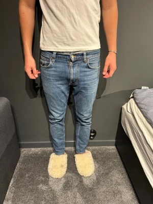 Blå slim fit jeans med klassisk look - Snygga blå slim fit jeans, normal midja. Jeansen har en klassisk tvätt och smal passform som sitter tajt längs benen. Perfekta för dig som gillar en stilren och enkel look. Tillverkade i denim med stretch för extra komfort. Modellen e lean Dean och stolek 29/28 bra skick.