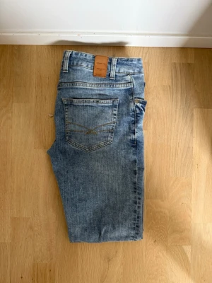 Ljusblå jeans - Säljer ett par ljusblå slim fit jeans från Hansen & Jacob i storlek 31/32. Använda ett fåtal gånger och passar perfekt för dig som gillar en enkel och stilren look.