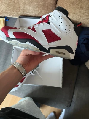 Vita och röda höga sneakers - Säljer ett par riktigt snygga höga sneakers i vitt och rött med svarta detaljer. Skorna har en chunky sula, perforerade paneler och cool design med synlig luftbubbla i sulan. Perfekta för dig som vill sticka ut med din stil.