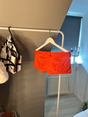 Röda shorts från Hollister - Snygga röda/rosa shorts från Hollister med klassisk femficksdesign och låg midja. Shortsen har knapp och dragkedja framtill samt Hollister-logga på ena fickan. Perfekta för varma sommardagar.
