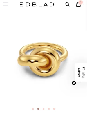 Guldfärgad ring från Edblad - Snygg guldfärgad ring från Edblad med unik knutdesign. Ringen har en blank, rundad yta och är tillverkad i metall med guldfinish. Perfekt för dig som vill ha ett statement-smycke som sticker ut. Helt ny med prislapp kvar , aldrig använt då jag redan har en! Den är i s/ 16.8 mm