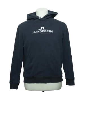 Mörkblå hoodie från J.Lindeberg - Snygg mörkblå hoodie från J.Lindeberg med vit logga och text på bröstet. Klassisk känguruficka framtill, ribbade muddar och justerbar huva med dragsko. Perfekt för en avslappnad och stilren look.