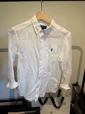 Vit linneskjorta från Polo Ralph Lauren - Säljer en vit linne skjorta från polo Ralph Lauren riktig snygg till ett par jeans/ linnebyxor eller varför inte till ett par shorts🤩 hör av dig vid fundering