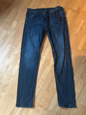 Mörkblå slim fit jeans - Snygga mörkblå jeans i slim fit-modell med klassisk femficksdesign och raka ben. Jeansen har en enkel look utan slitningar och är tillverkade i ett mjukt denimtyg som passar perfekt till vardagsstilen.