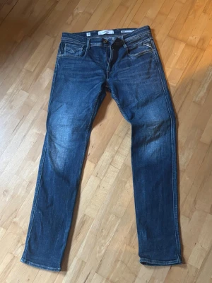 Mörkblå slim fit jeans - Snygga mörkblå slim fit jeans med klassiska fem fickor och kontrastsömmar. Jeansen har en lätt tvättad look och dragkedja i gylfen. Perfekta för en trendig och avslappnad stil.